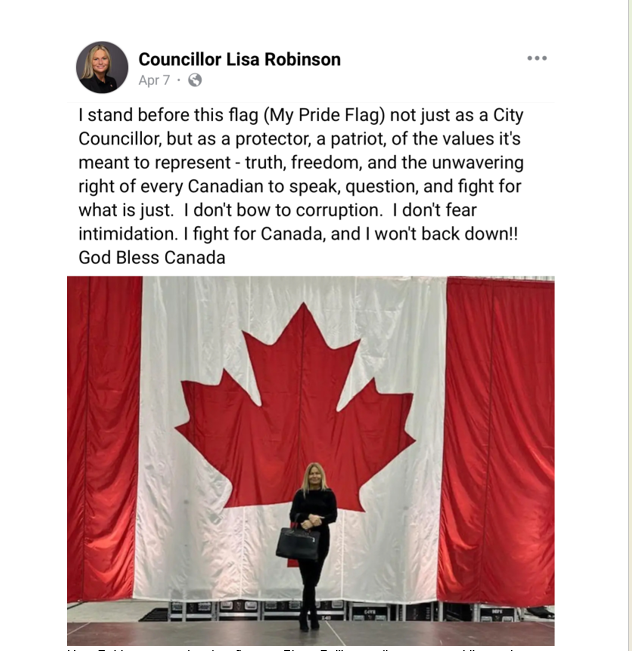 city councillor standing in front of a giant canadian flag.